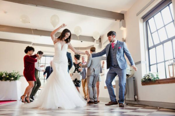 Newly wed couple are enjoying dancing with all of their guests on their wedding day.